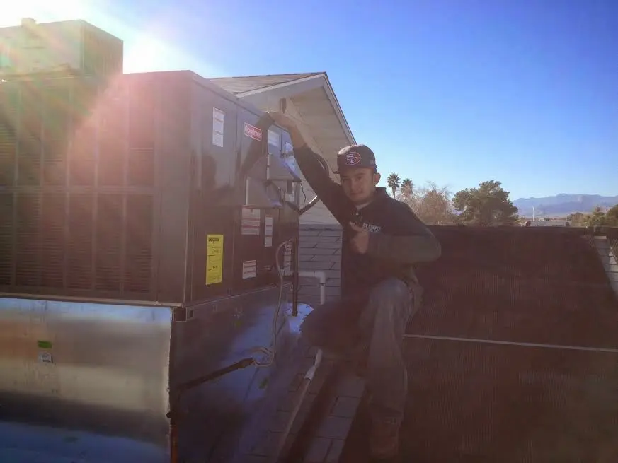 HVAC technician performing Heat Pump Repair on a rooftop unit in Douglass Hills